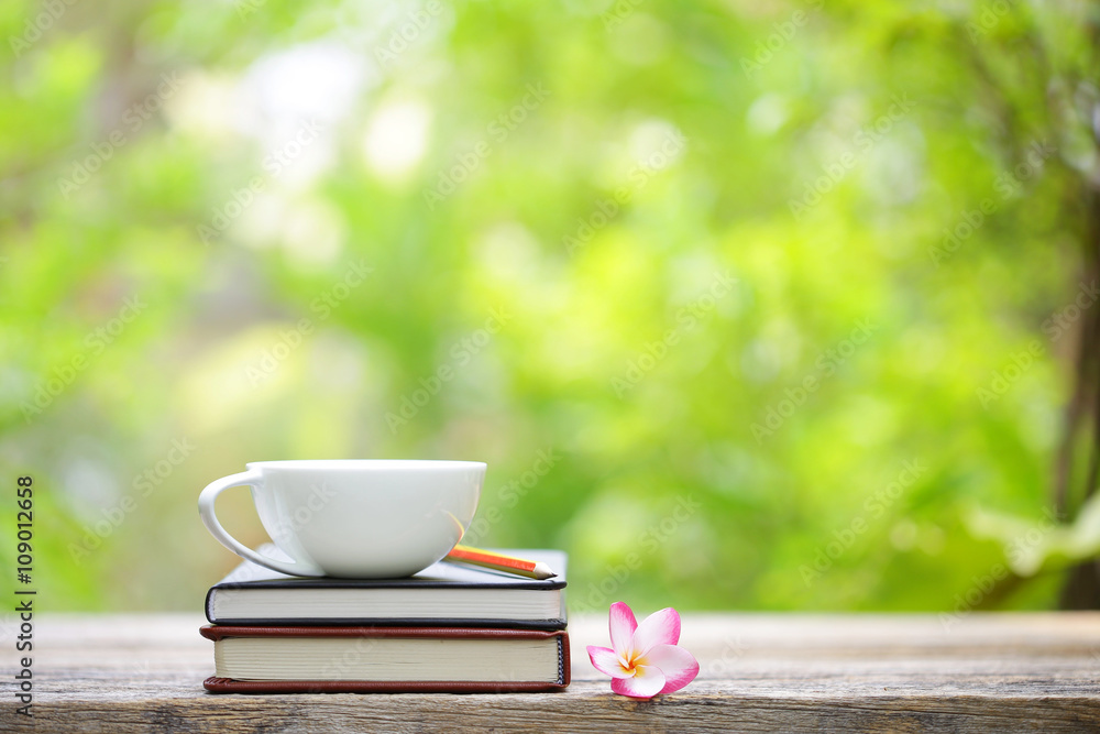 Notebook with flower and cup on wooden table Notebook with flower and cup on wooden table