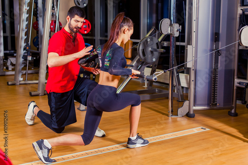 Slika na platnu fitness, sport, training and people concept - Personal trainer helping woman wor