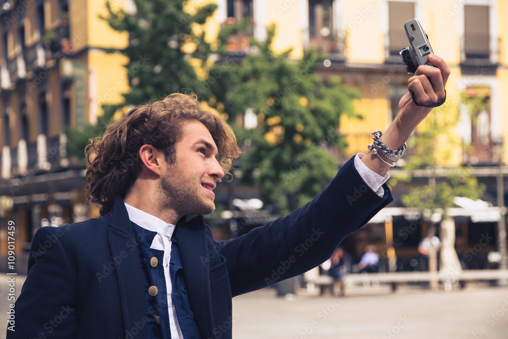 Young man taking self portrait with retro camera. Selfie Young man taking self portrait with retro camera. Selfie