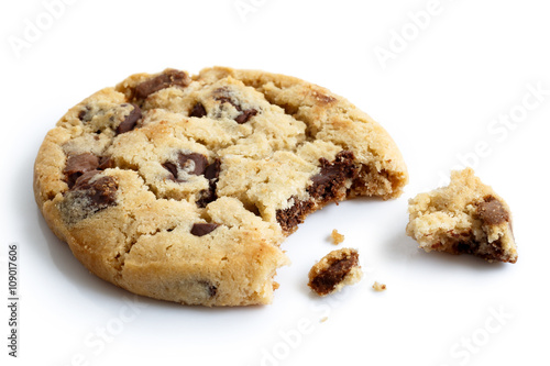 фотография Single light chocolate chip cookie, bite missing with crumbs, is