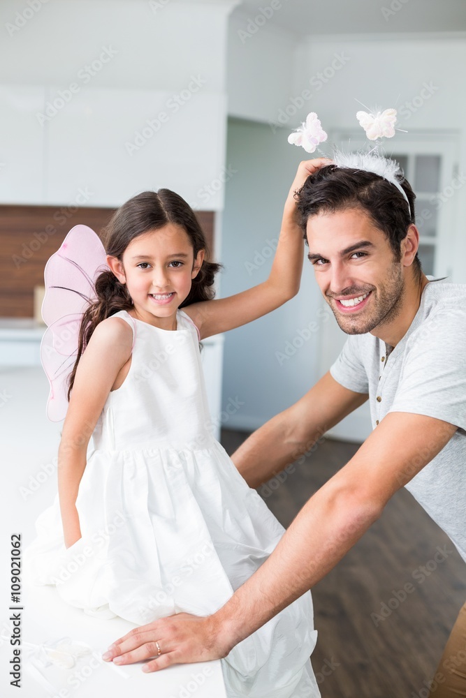 Portrait of smiling father with butterfly headband and daughter Portrait of smiling father with butterfly headband and daughter