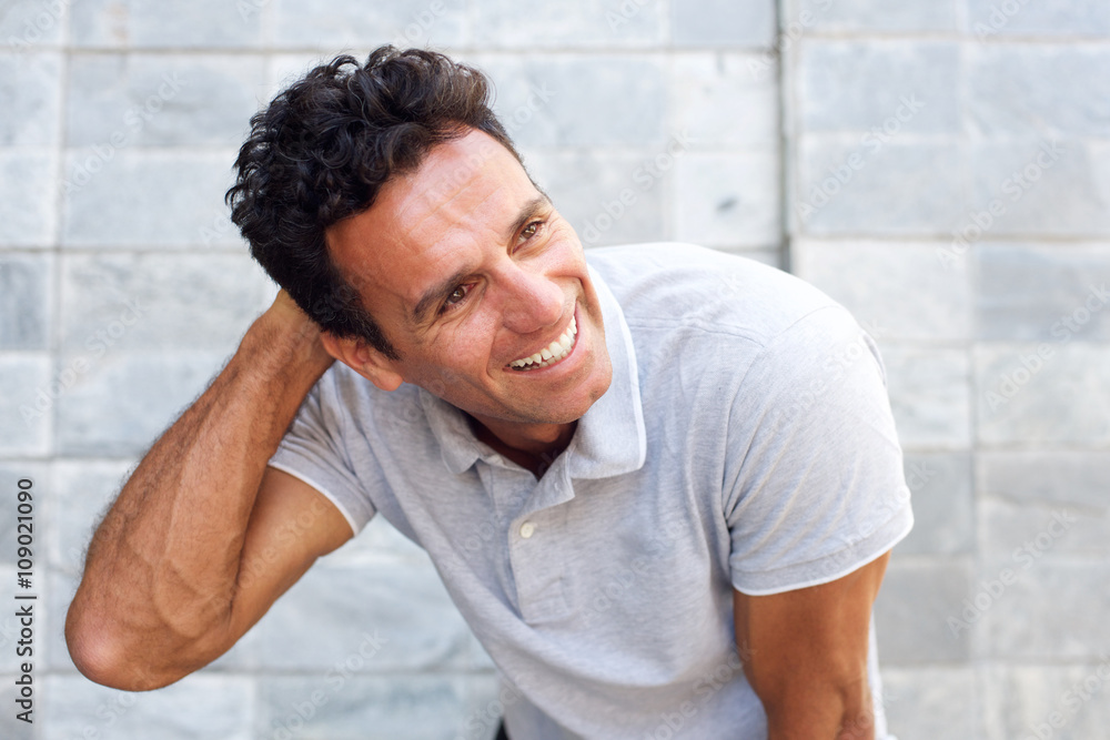Handsome older man laughing with hand in hair Handsome older man laughing with hand in hair