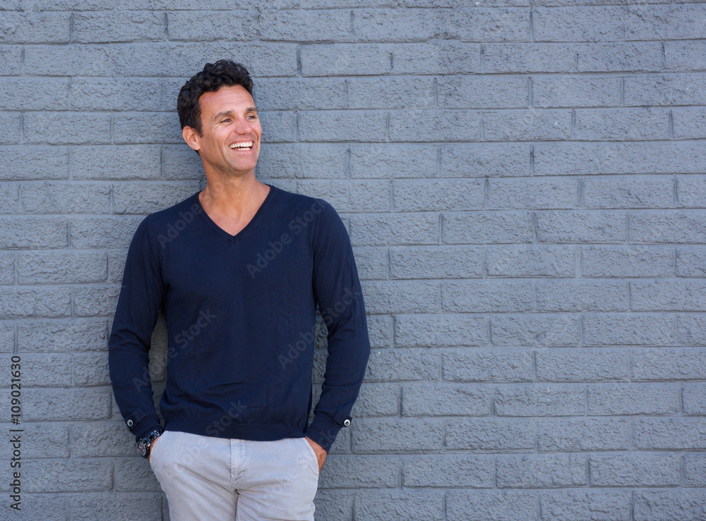 Fit older man smiling against gray wall Fit older man smiling against gray wall