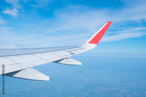 Wing of an airplane flying with Clouds and sky . air transport to travel.