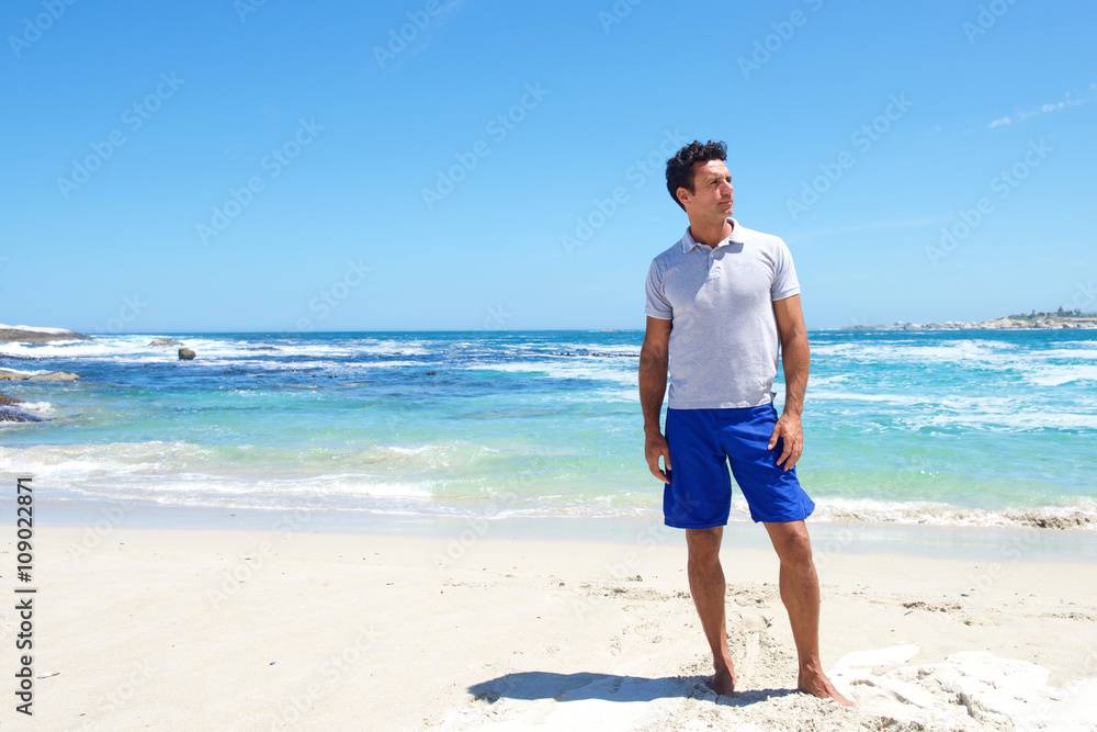 Fit middle aged man standing barefoot at the beach