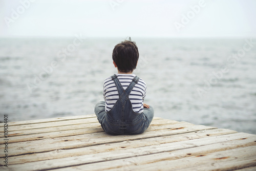 niño pensativo mirando el mar Fototapet