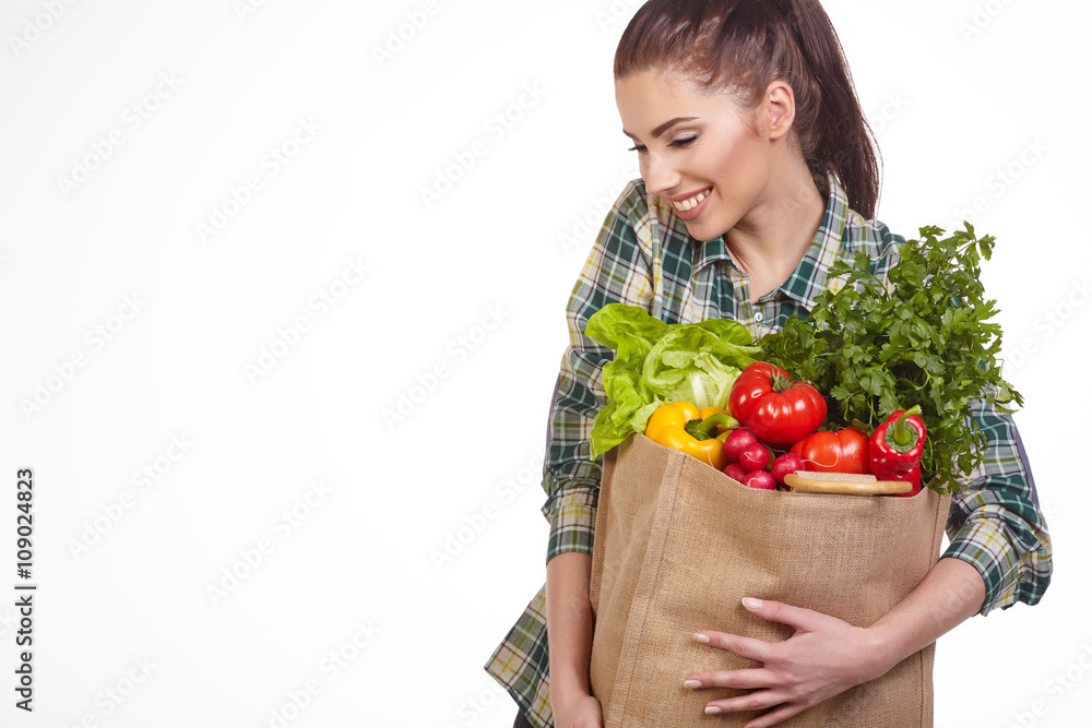 Isolated woman holding a shopping bag full of vegetables Isolated woman holding a shopping bag full of vegetables