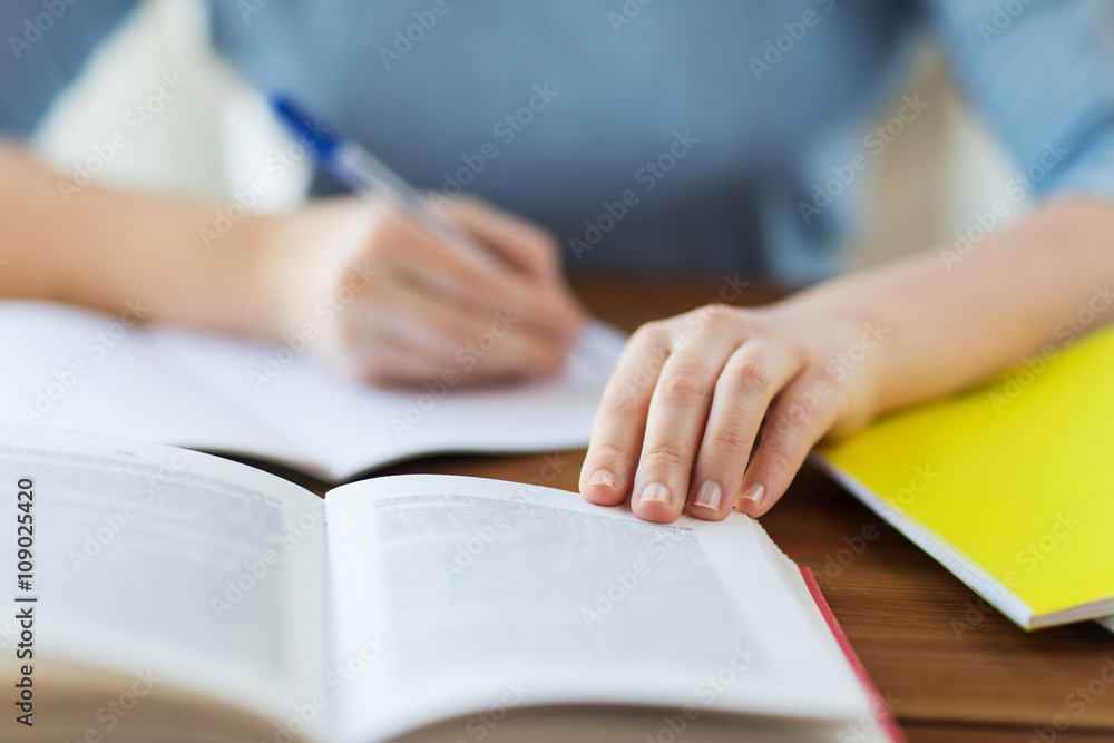 close up of student with book and notebook at home close up of student with book and notebook at home