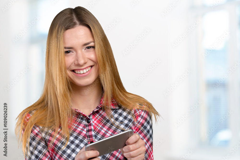 Cheerful young woman holding mobile phone Cheerful young woman holding mobile phone