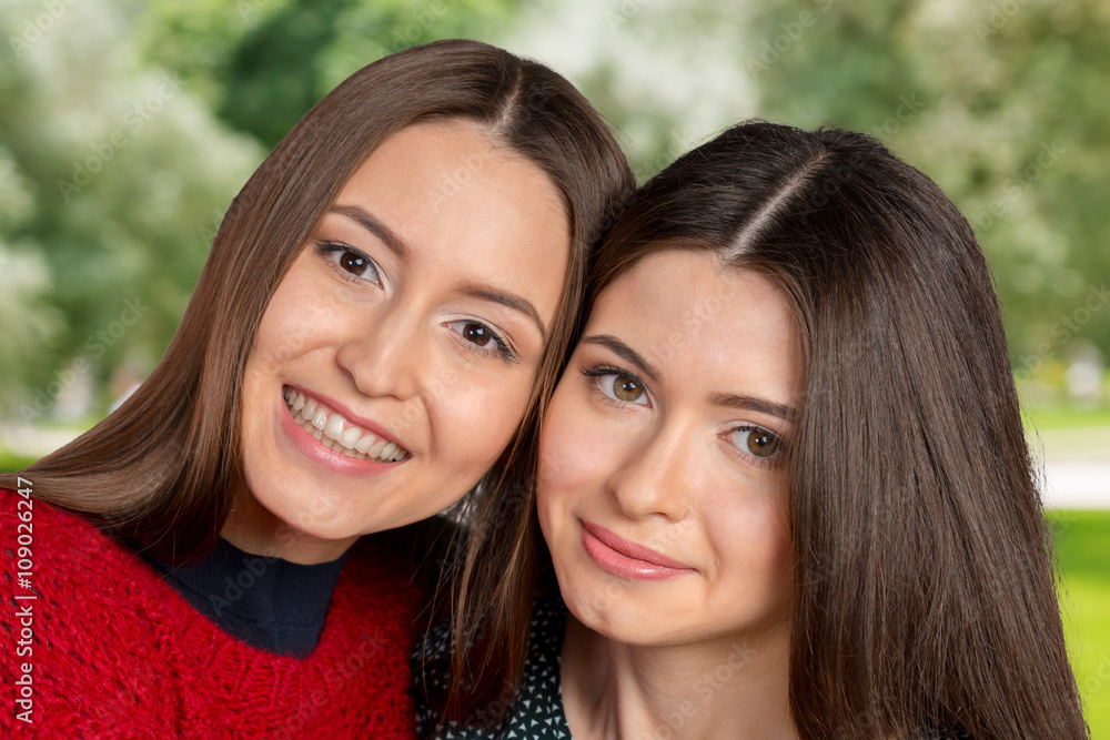 Two beautiful sisters hugging each other and smiling Two beautiful sisters hugging each other and smiling