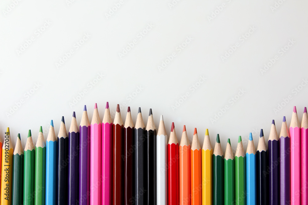 many colored pencils are in the shape of a wave near each other on a white isolated background many colored pencils are in the shape of a wave near each other on a white isolated background