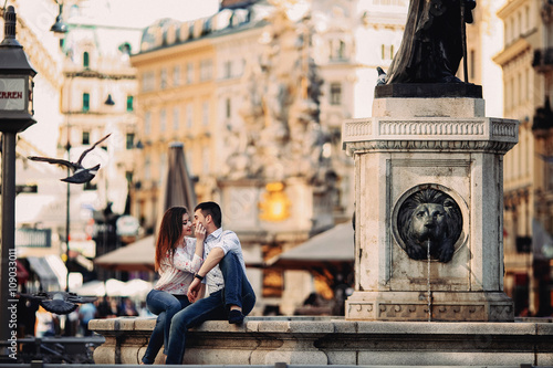 Canvas Print Couple in love sitting near fountain