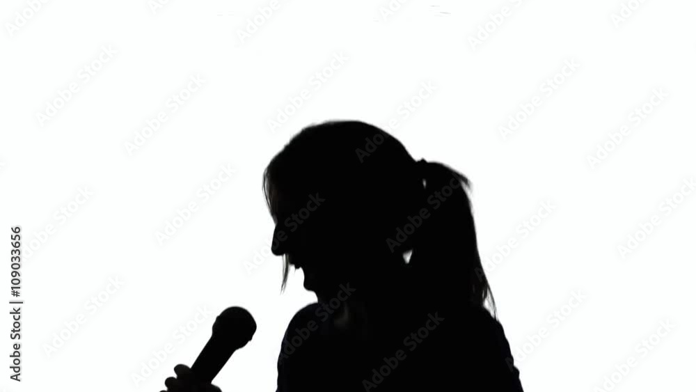 A crazy singer (a woman) moving, shaking, singing into a microphone. Silhouette shot. A crazy singer (a woman) moving, shaking, singing into a microphone. Silhouette shot.