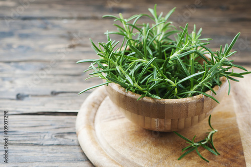 Fresh green aromatic rosemary on the wooden table