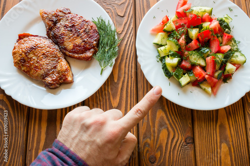 Konstfotografi vegetarian chooses salad instead of fried meat