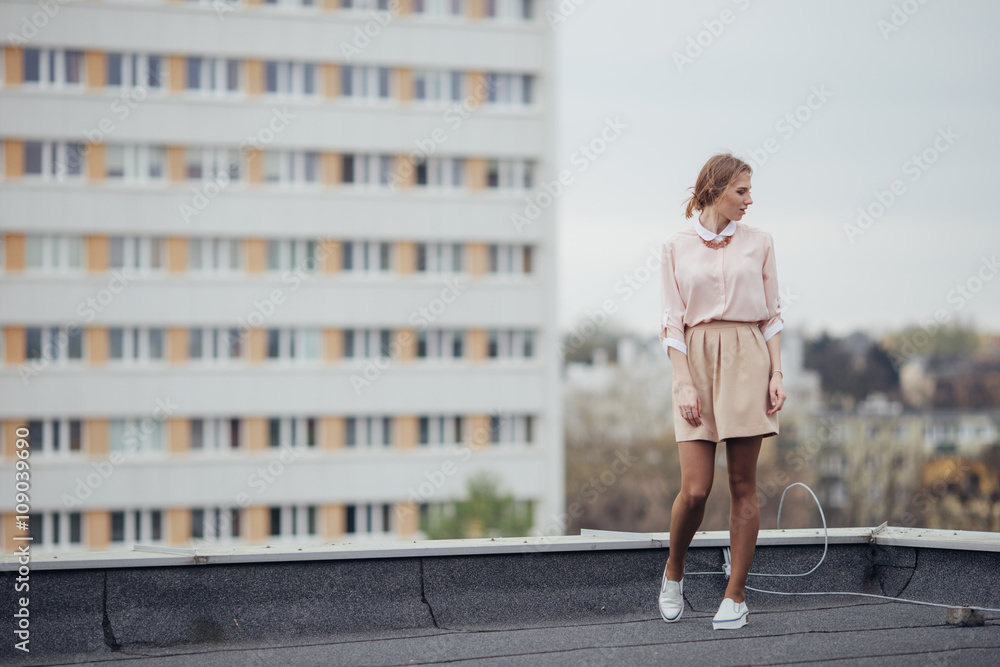 Beautiful girl walking on the building roof
