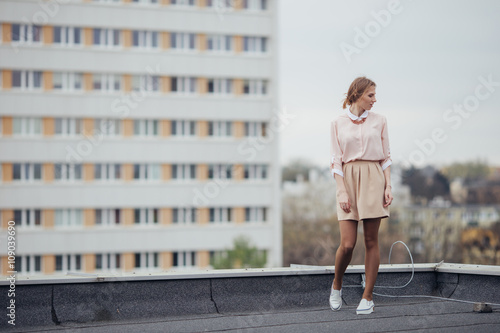 Beautiful girl walking on the building roof