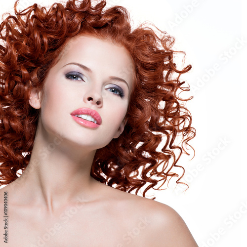 Beautiful young woman with red curly hair.