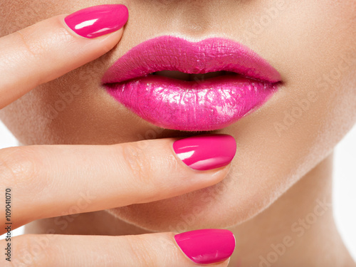 Fotografie Closeup woman hand with pink nails near lips.