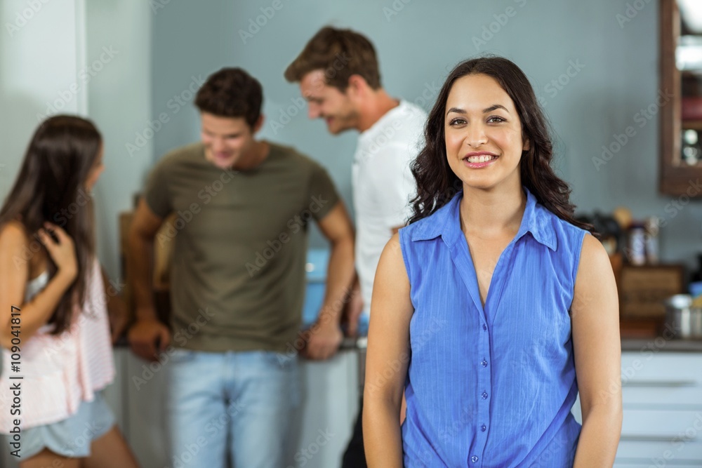 Happy young woman with friends in background at home Happy young woman with friends in background at home