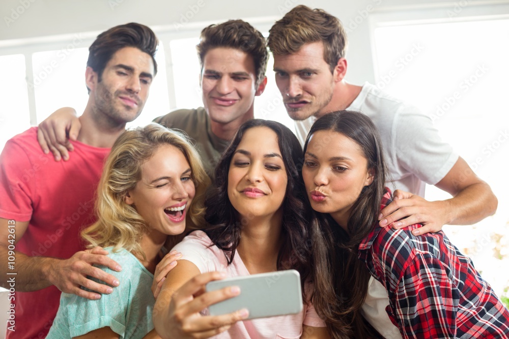Friends making faces while taking selfie at home Friends making faces while taking selfie at home