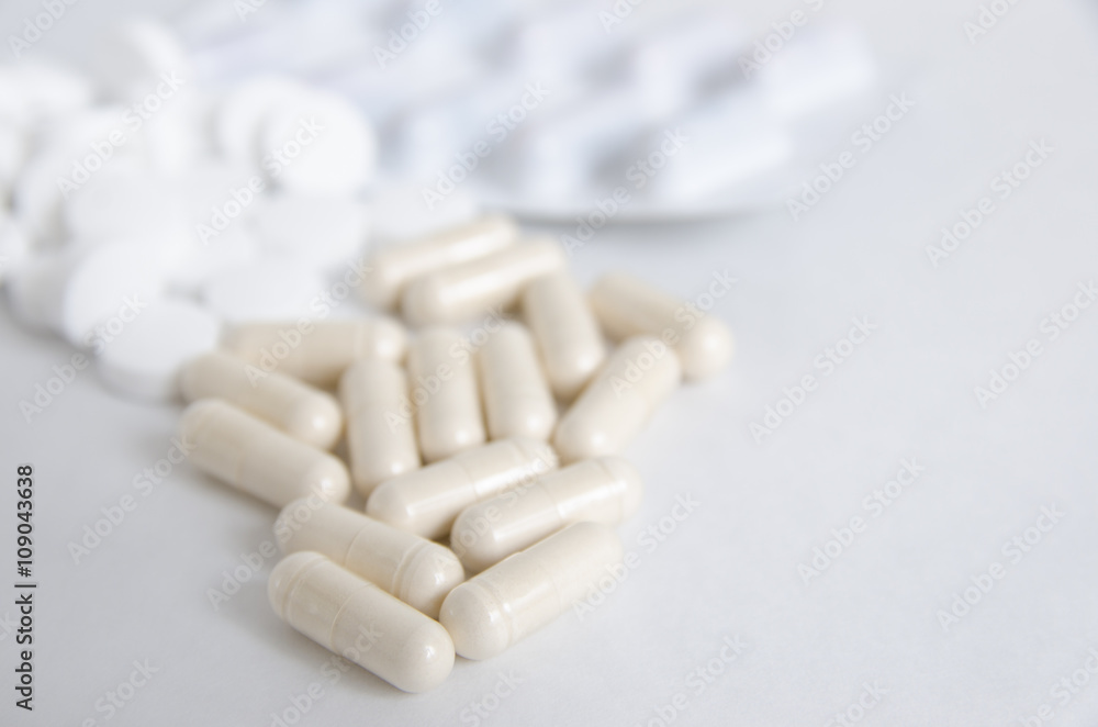 Pills and tablets in capsule on white isolated background