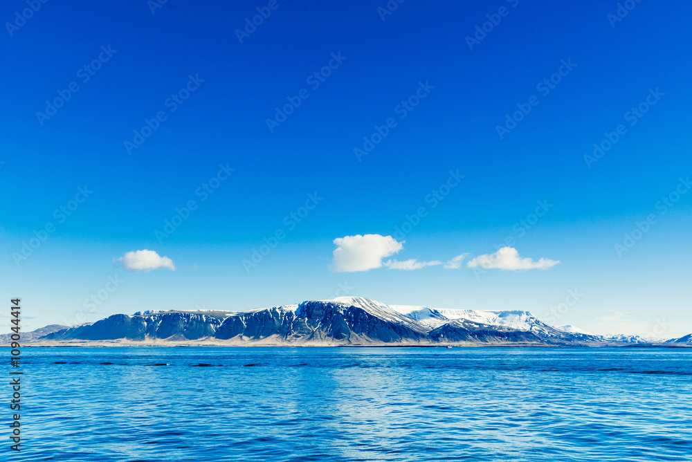 Blue ocean with distant mountains