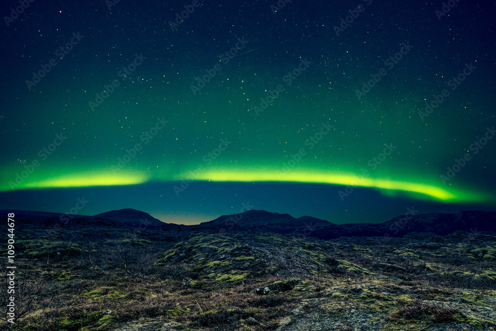 Northern lights over distant mountains