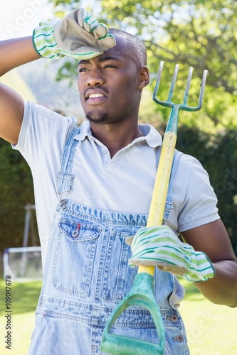 Young man posing with rake photo