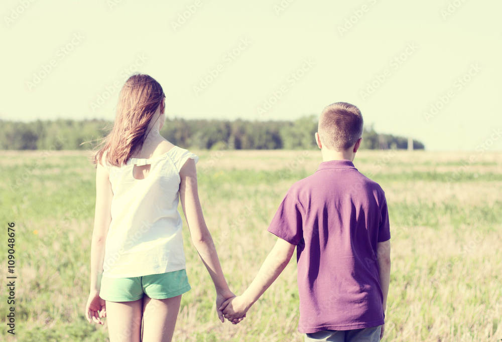 Summer sunny day park stands boy with girl holding hands enjoy nature, Meadow, fun small little family relationships, idea concept happiness lifestyle Summer sunny day park stands boy with girl holding hands enjoy nature, Meadow, fun small little family relationships, idea concept happiness lifestyle