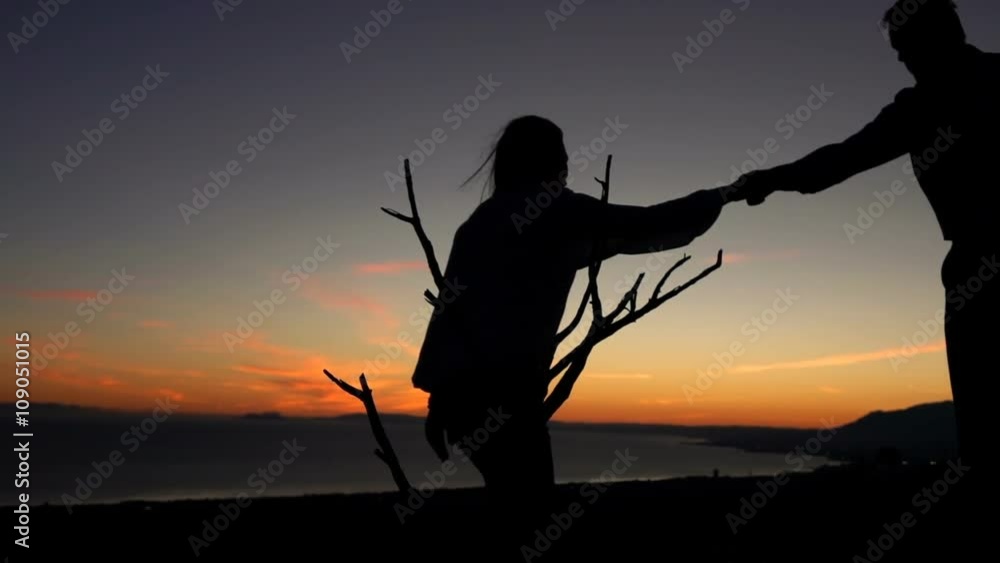 Man helping his girfriend climbing during sunset, super slow motion
Man helping his girfriend climbing during sunset, super slow motion