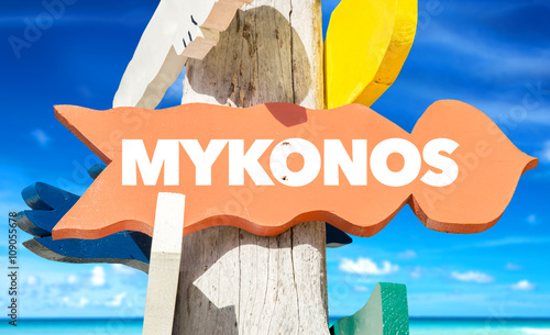 Mykonos signpost with beach background