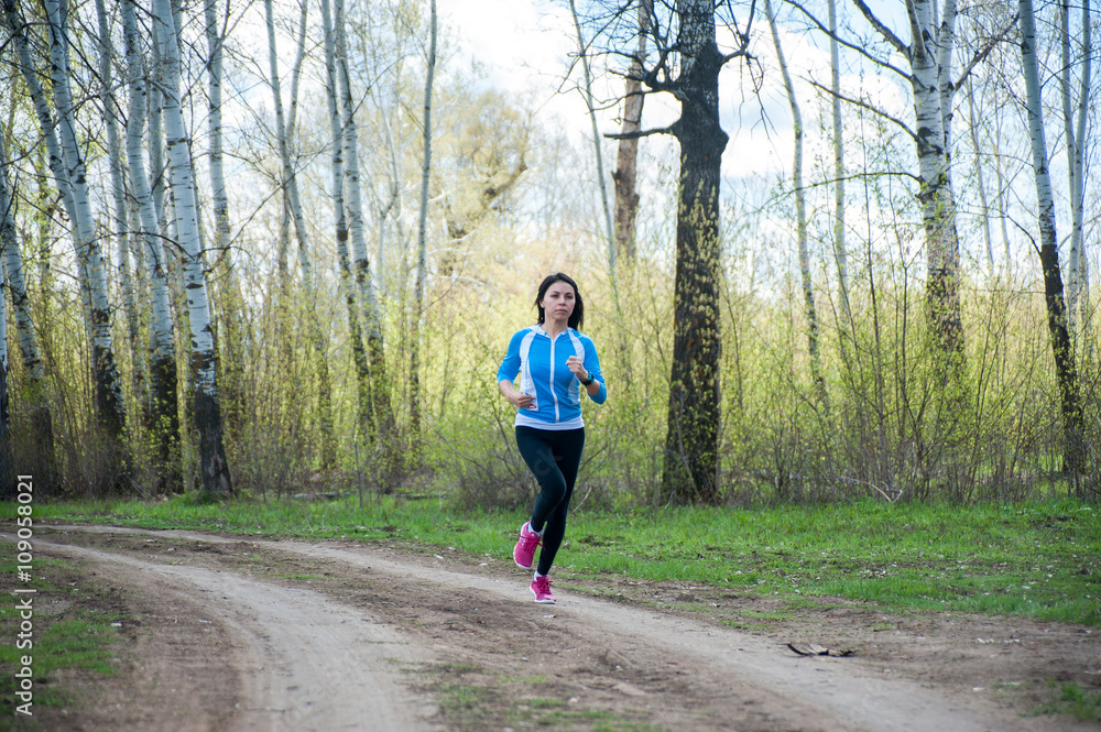 Girl in sport tights black runs through the forest Girl in sport tights black runs through the forest