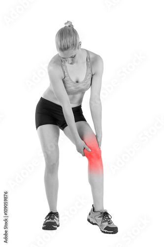 Young woman massaging her painful knee