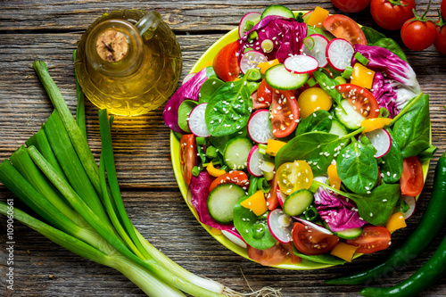 Fresh vegetable salad on wooden background