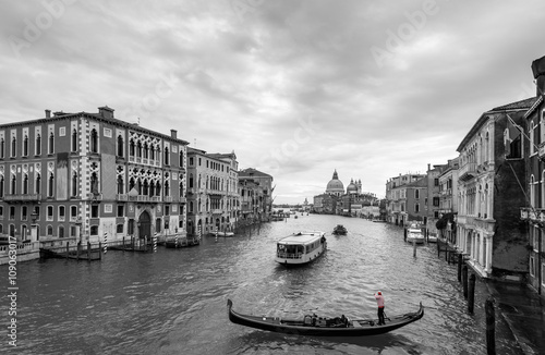 Beautiful view of traditional Gondola and boats on Canal Grande with Basilica di Santa Maria della Salute church in background at a cloudy day, Venice (Venezia), Italy, Europe, black and white   © AR Pictures