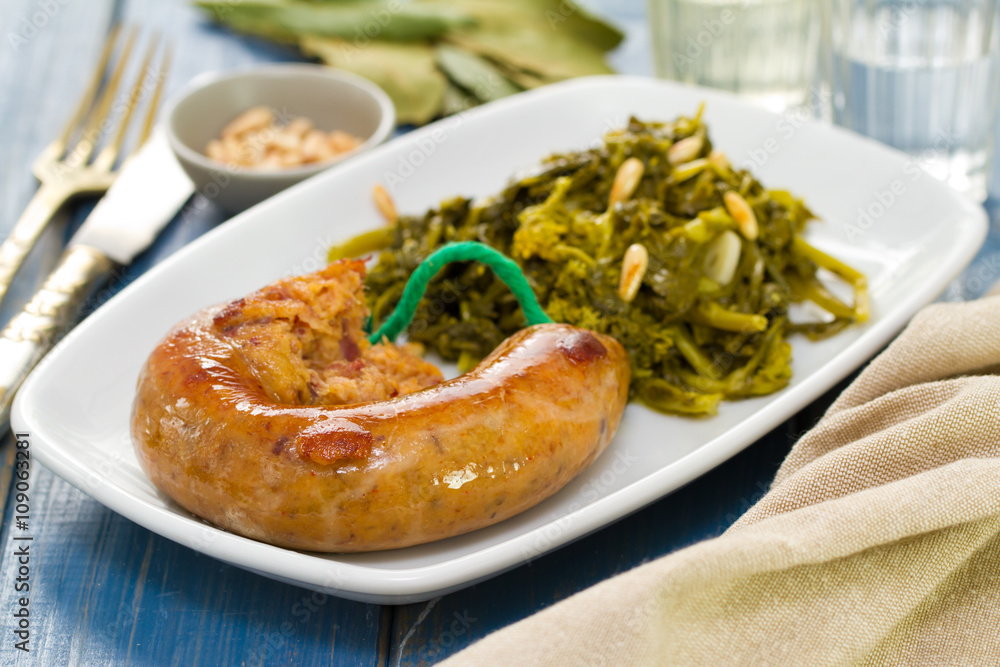 traditional portuguese smoked sausage with greens on white plate and glass of wine