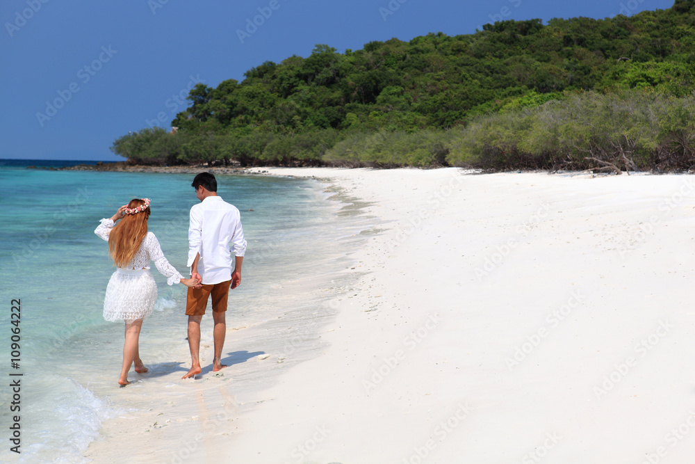 Loving wedding couple on beach in white dresses