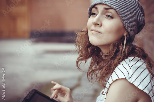 Beautiful hipster young girl works on the tablet
