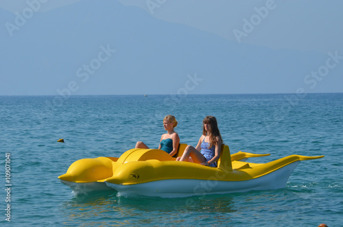Girls on yellow pedalo paddle boat in the Mediterranean sea, Kusadasi, Turkish Riviera, Turkey © lembrechtsjonas