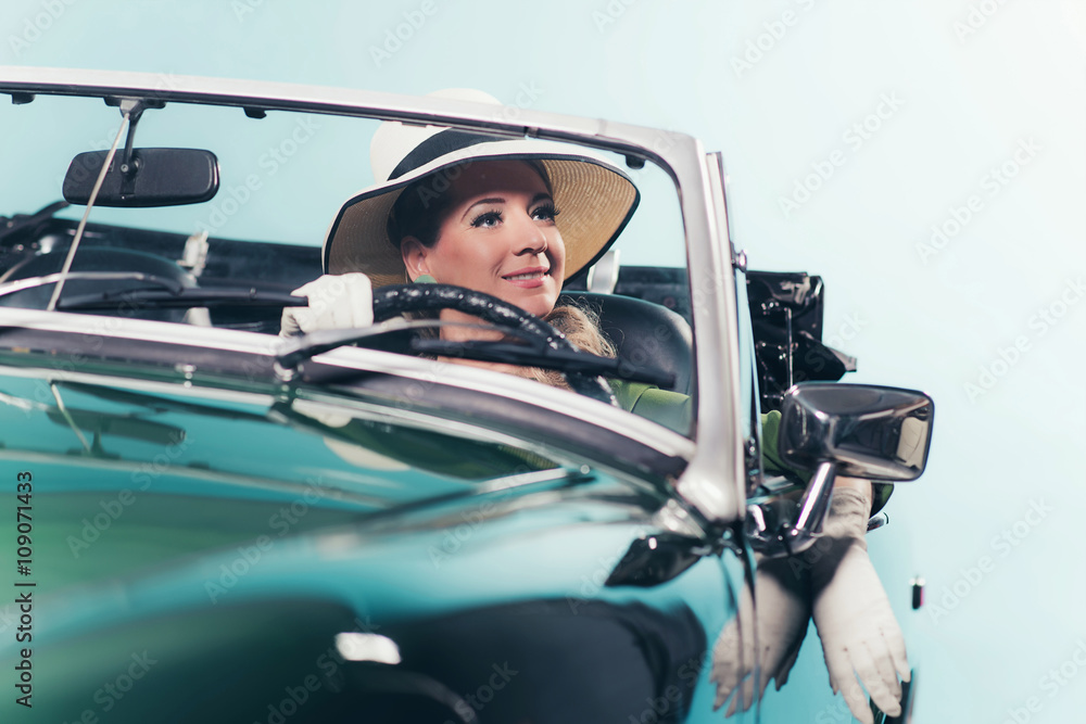 Smiling retro 60s woman with driving sports car.