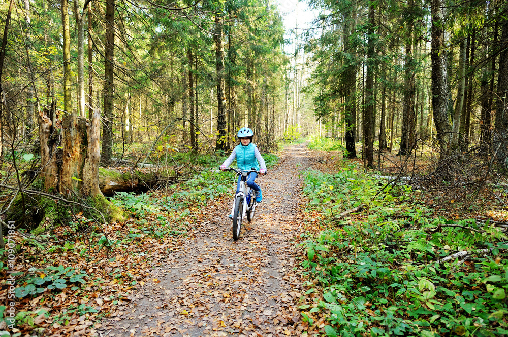 Little girl riding on bicycle in the forest Little girl riding on bicycle in the forest