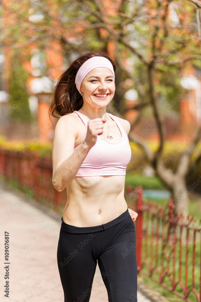 Young happy woman jogging along the street Young happy woman jogging along the street