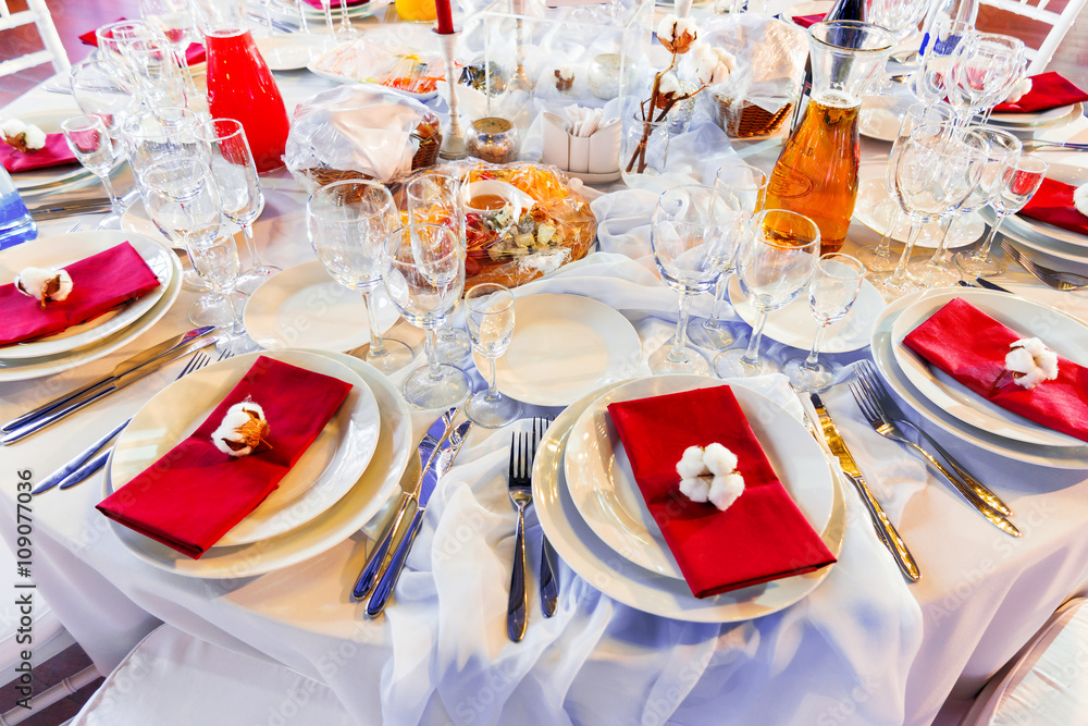 Fototapeta premium Table set for banquet with cutlery. Cotton flower decoration.