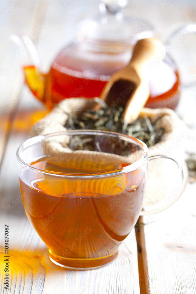 Cup of tea, tea leaves and teapot on wooden table Cup of tea, tea leaves and teapot on wooden table