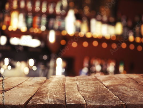 Empty wooden table and bokeh pub  bar of restaurant background.