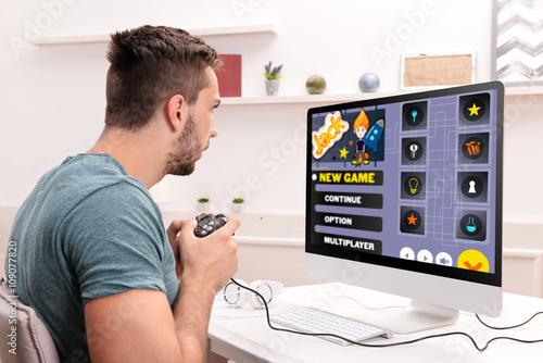 Young man playing computer ...