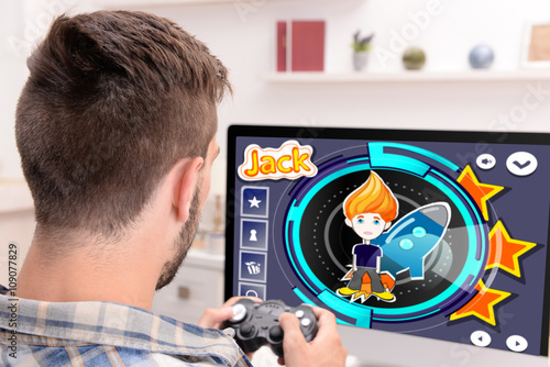 Young man playing computer ...
