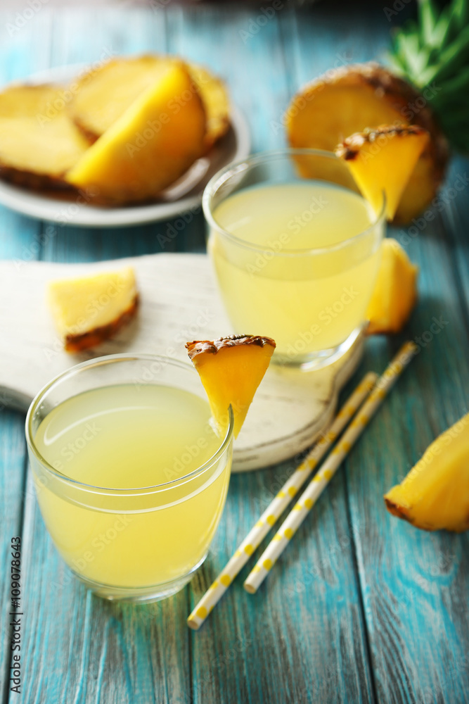 Glasses of pineapple juice on a blue wooden table Glasses of pineapple juice on a blue wooden table
