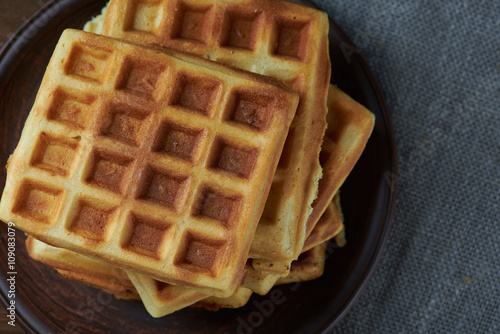 Top view at plate of belgium waffles on rustic background